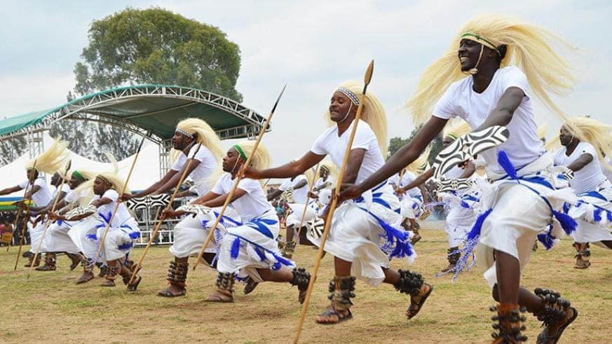 Traditional Rwandan Intore dancers with golden sisal umugara headdresses and spears