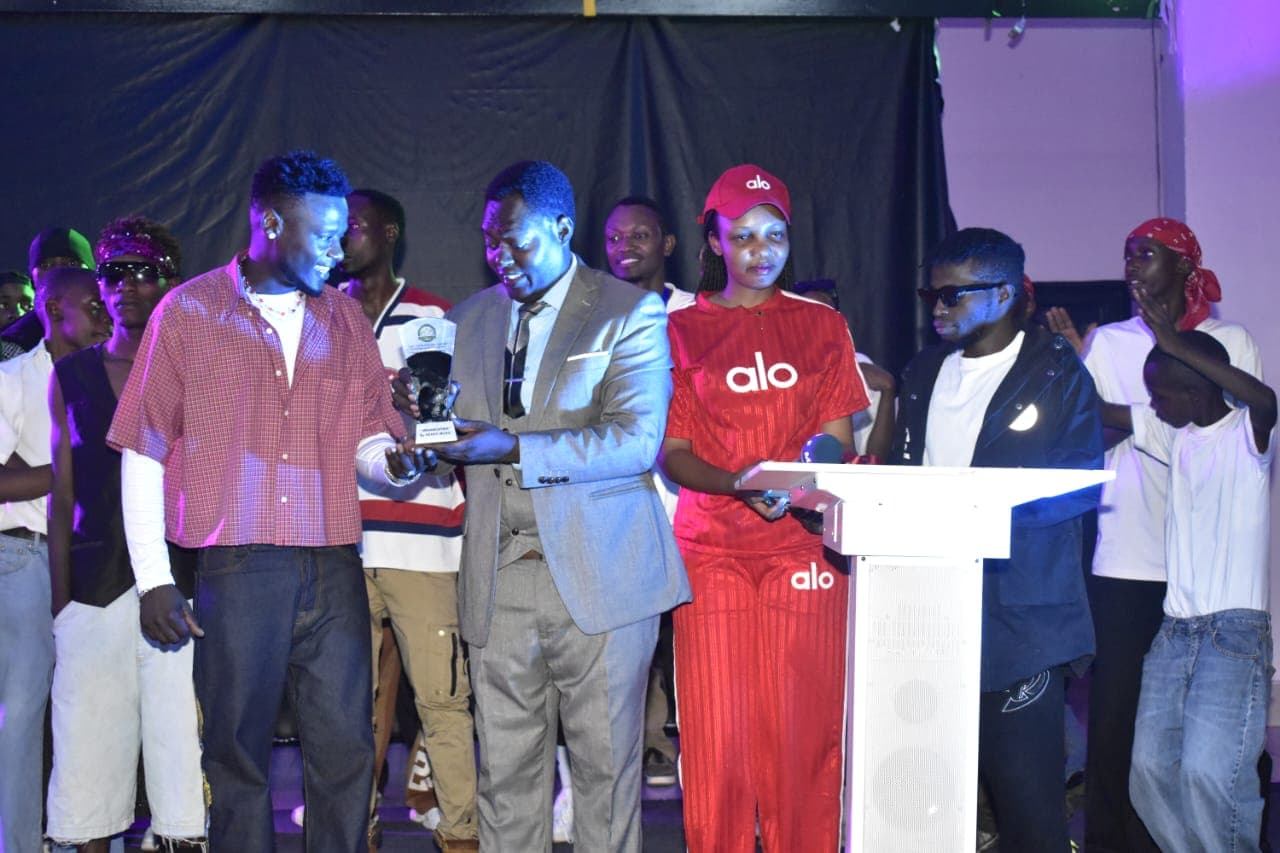 RFM Organization Representative Mutasire Eric presenting award to emerging talent